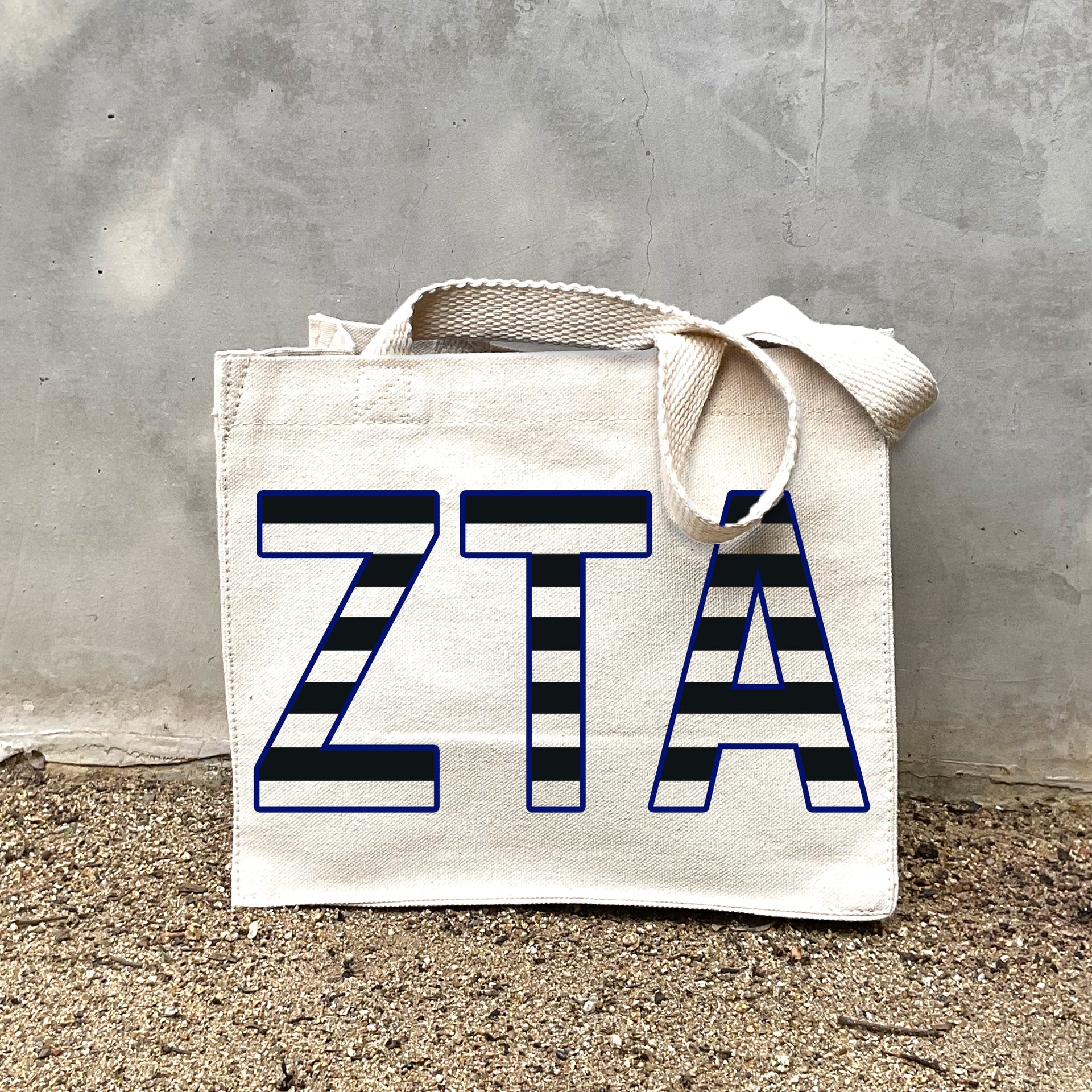 Model carrying the Zeta Tau Alpha small black and white stripe tote.