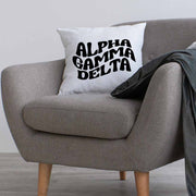Alpha Gamma Delta sorority name digitally printed in black ink mod style design on a throw pillow cover.