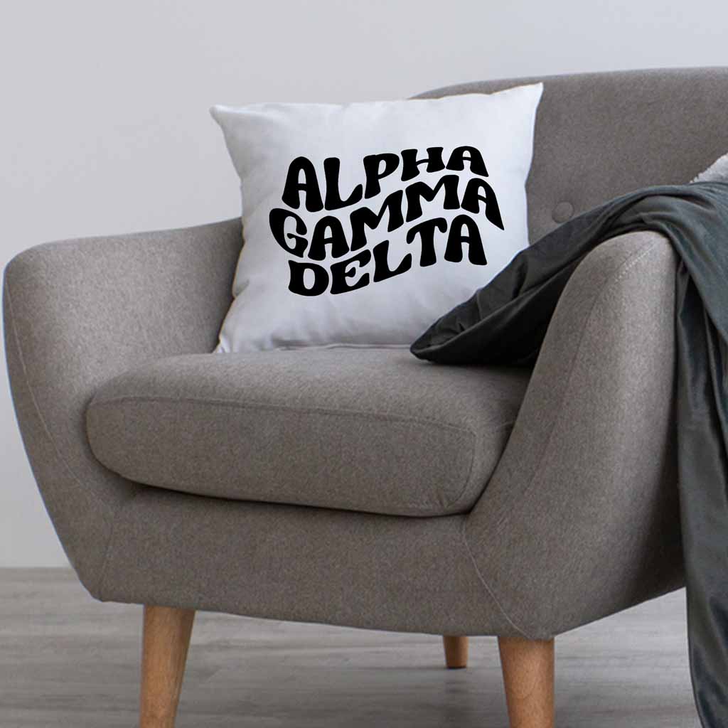 Alpha Gamma Delta sorority name digitally printed in black ink mod style design on a throw pillow cover.