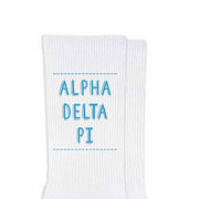 Alpha Delta Pi sorority name in sorority colors digitally printed on white cotton crew socks is the perfect accessory for any event.