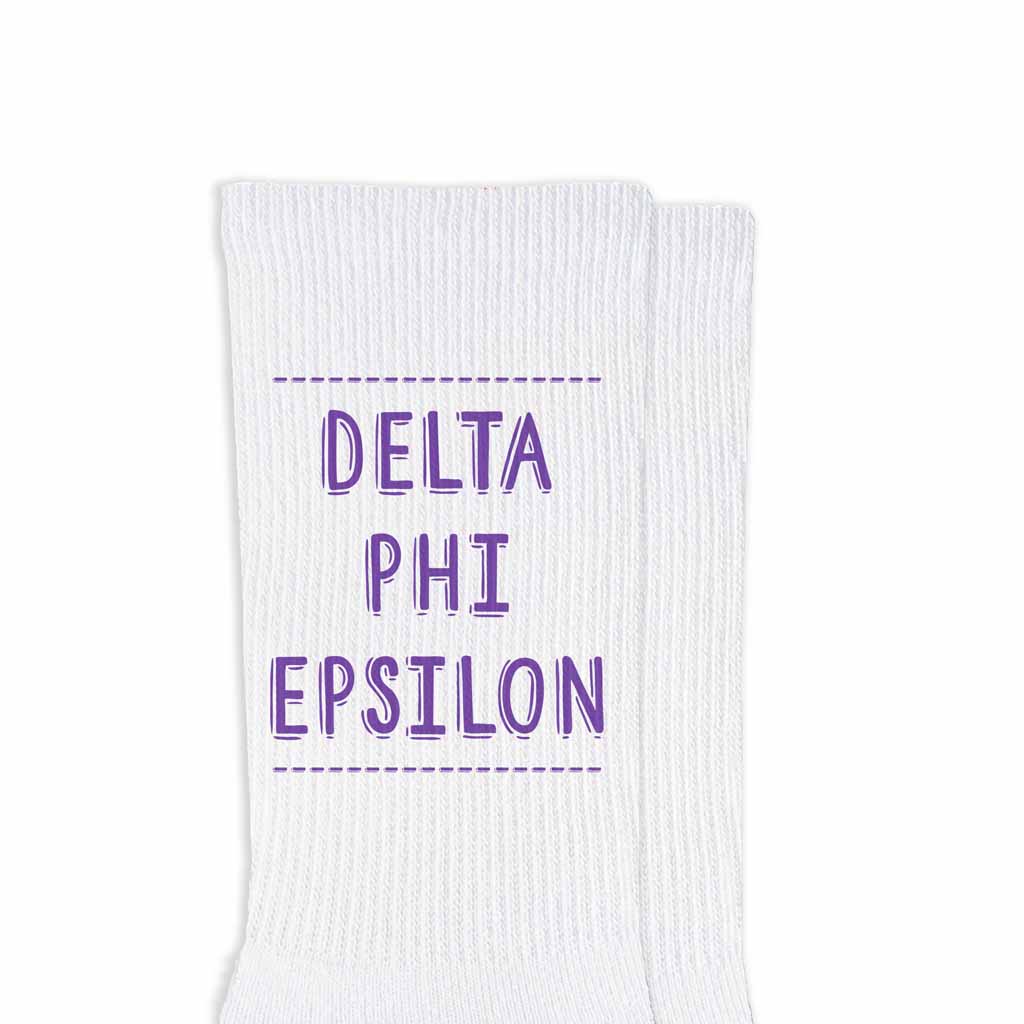 Delta Phi Epsilon sorority name design printed in sorority colors on comfy white cotton crew socks is the perfect gift for your sorority sisters.