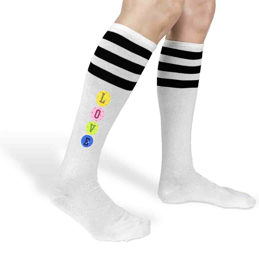 Love pickleball design custom printed on the side of striped knee high socks.