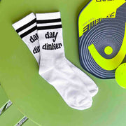 Day Dinker is custom printed on the side of the white cotton crew socks with black stripes.
