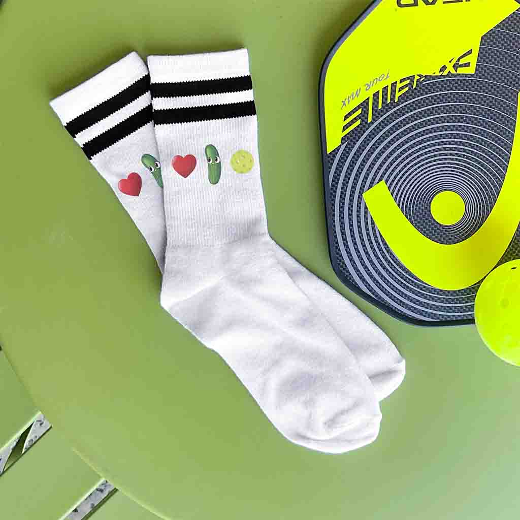 Pickleball love in emoji form is custom printed on the side of the white cotton crew socks with black stripes.