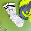 Pickleball love in emoji form is custom printed on the side of the white cotton crew socks with black stripes.