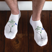White no-show golf socks with the phrase "MY FAVORITE HOLE" printed on top, featuring a playful design of a cocktail glass with a 19th hole flag and an olive. Perfect for golfers who love celebrating after a round.