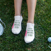 White no-show golf socks featuring the phrase "I'm That Crazy Girl Who Loves to Golf" printed on top, designed for fun-loving and passionate women golfers. A stylish and comfortable gift for golf enthusiasts.