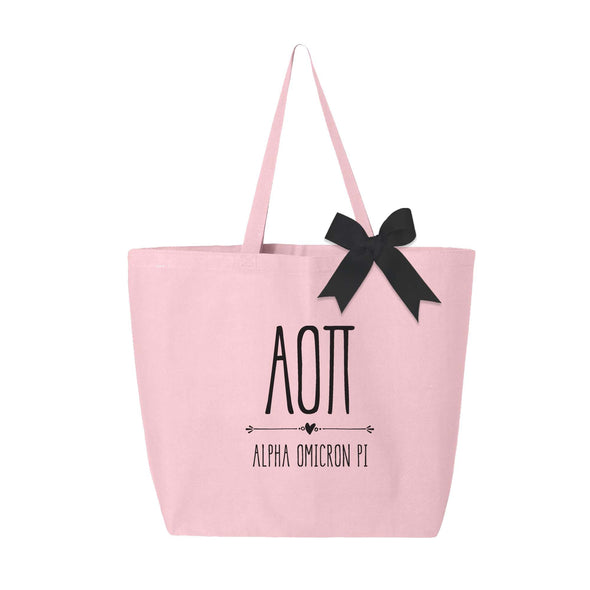 Alpha Omicron Pi sorority name and letters custom printed on pink canvas tote bag with black bow.