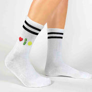 Emojis that say Love pickleball digitally printed on the side of white cotton crew socks with black stripes are perfect for the pickleballer.