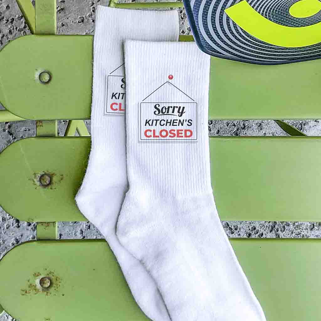 Kitchen is closed pickleball inspired design by sockprints digitally printed on white crew socks.