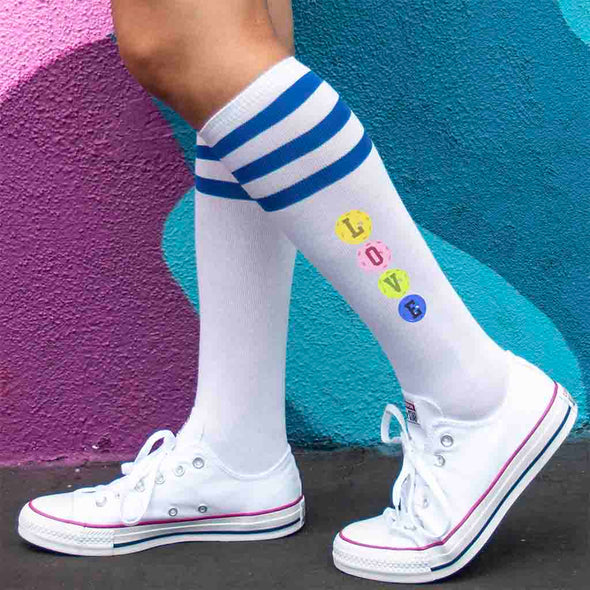 Pickleball design custom printed by sockprints on the side of striped knee high socks.