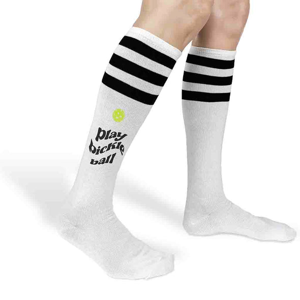 Play pickleball design custom printed on the side of striped knee high socks.