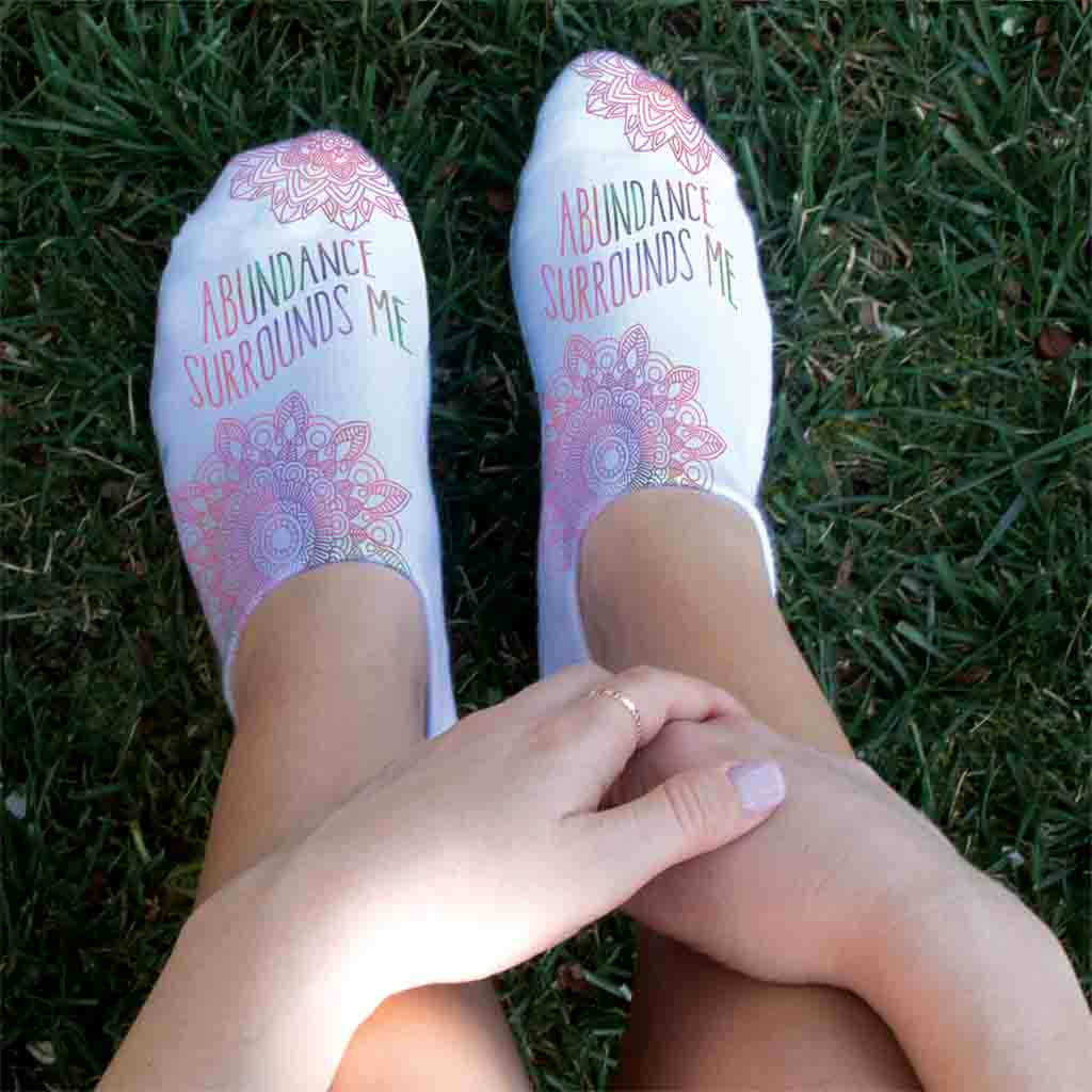 Abundance surround me self affirming mantra digitally printed on white cotton no show socks.