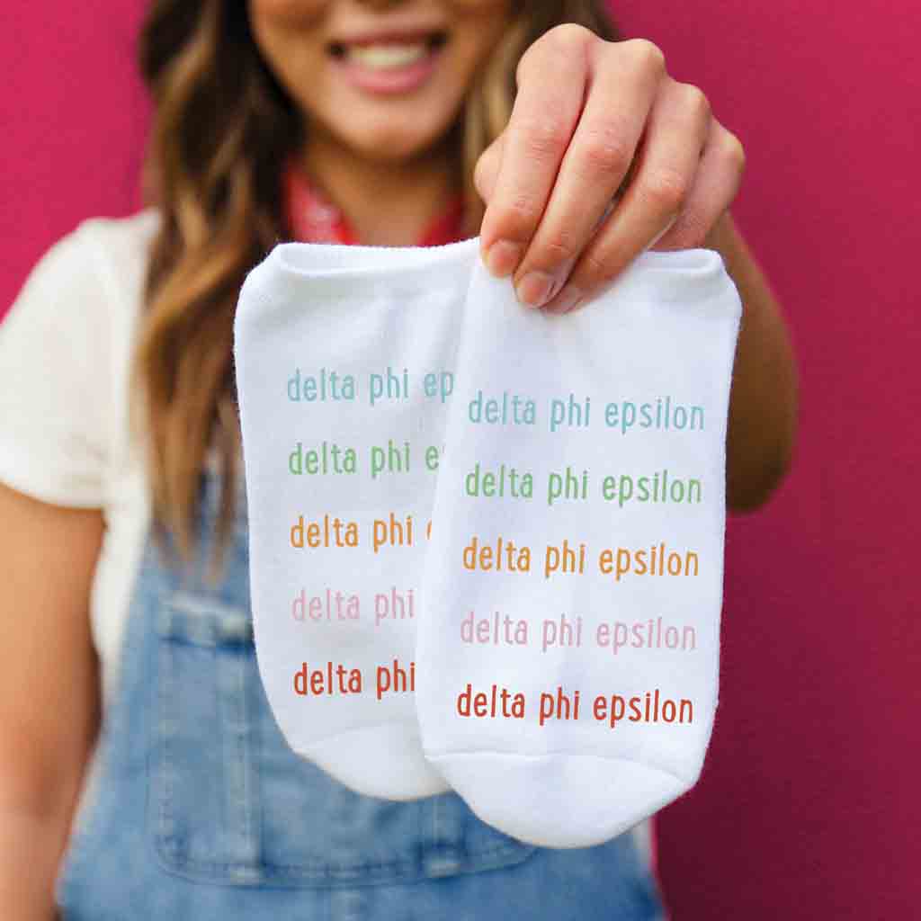 Delta Phi Epsilon sorority name in repeating rainbow letter design custom printed on no show socks