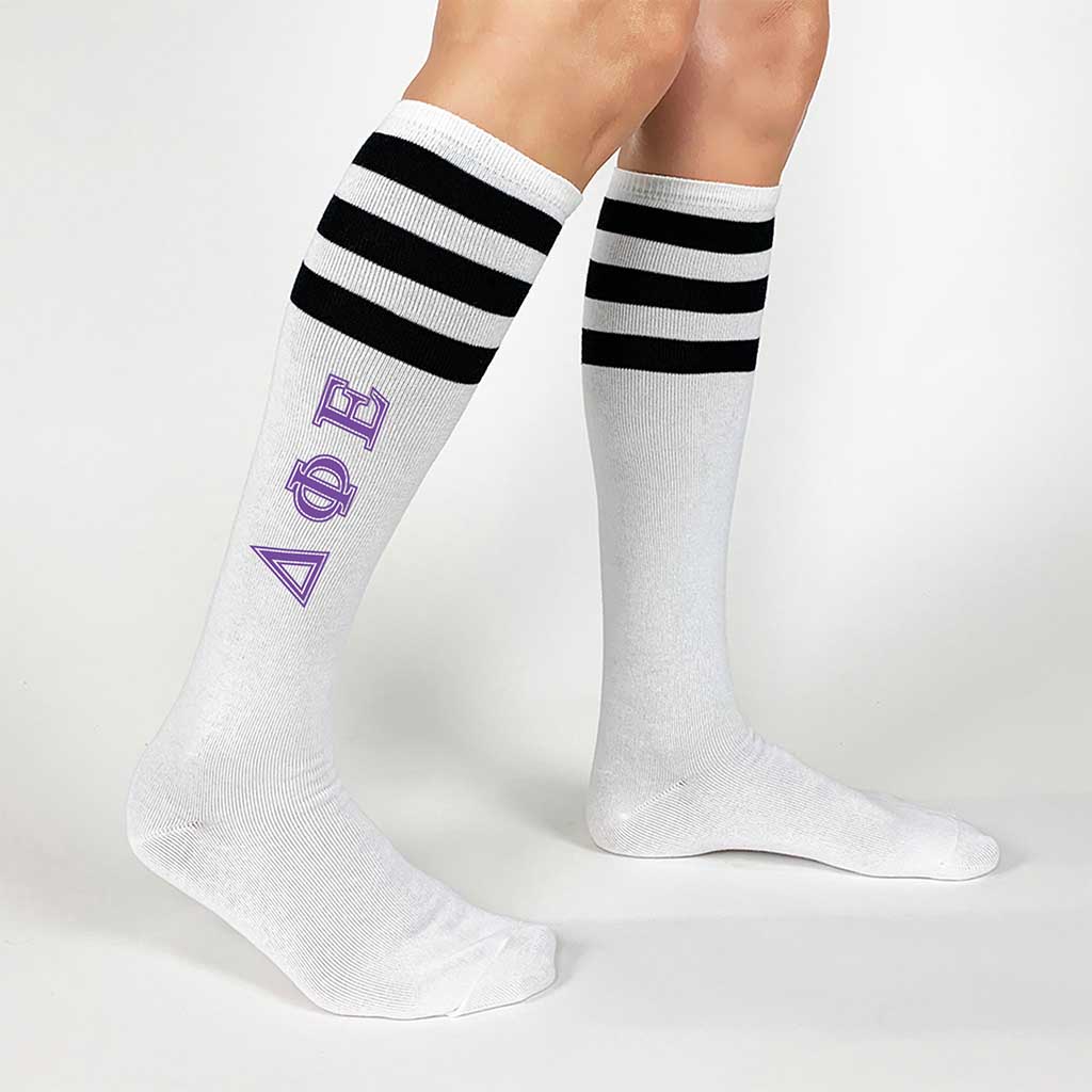 Delta Phi Epsilon sorority letters digitally printed in pink on comfy cotton black striped knee high socks