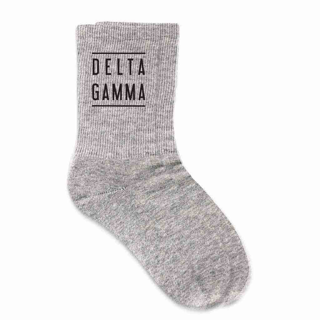 Delta Gamma sorority crew socks with the sorority name printed on the gray cotton socks