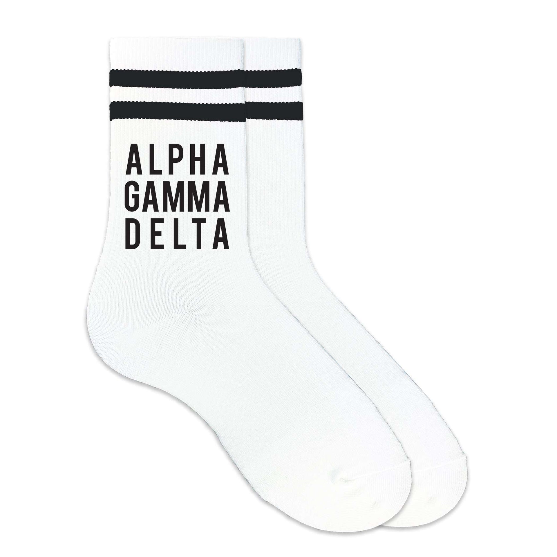 Alpha Gamma Delta sorority name in black ink digitally printed on the side of the black striped crew socks.