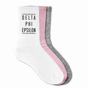 Delta Phi Epsilon sorority cotton crew socks digitally printed with black ink on the sides of each sock.