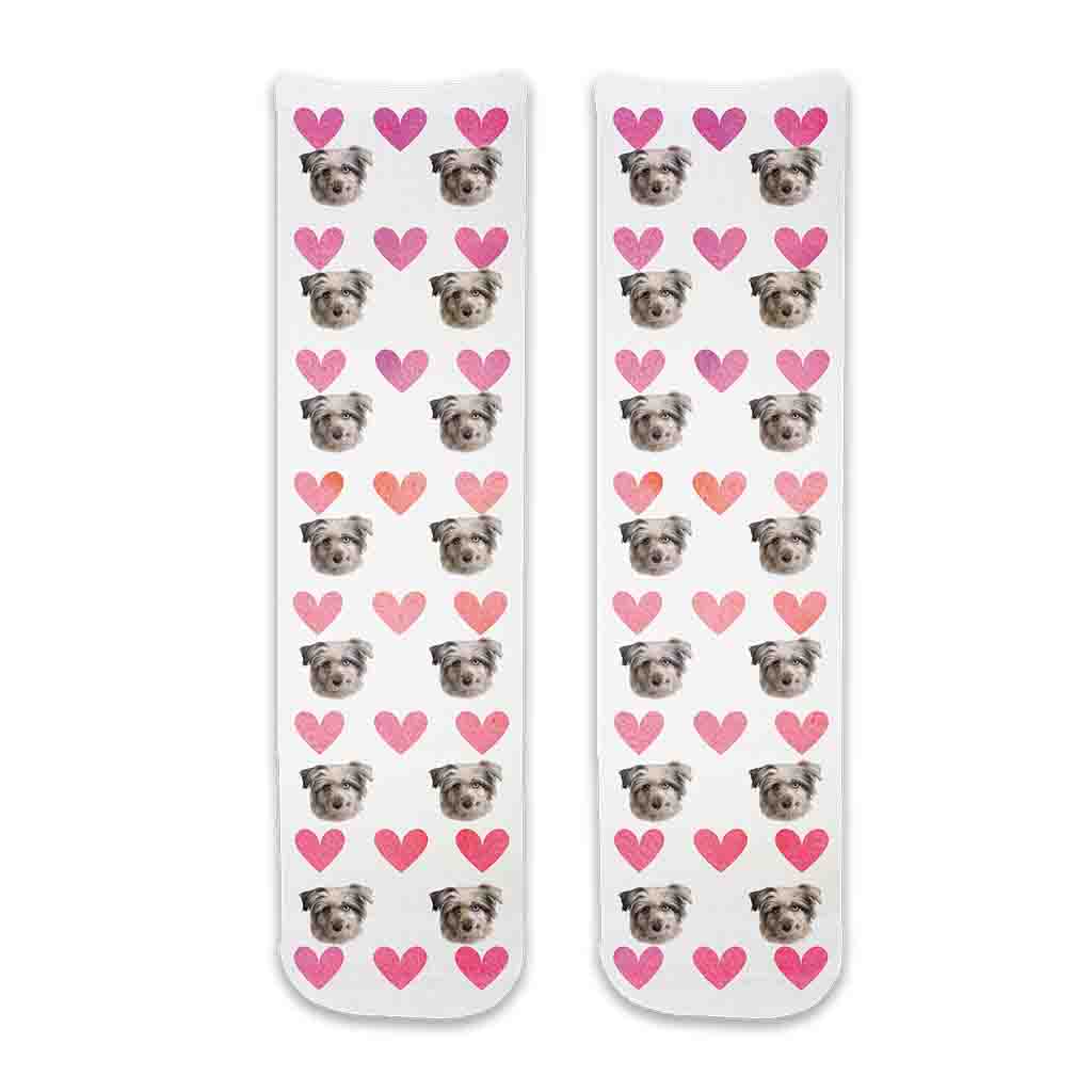 Custom pet photo socks personalized with your dogs face printed all over the cotton crew socks with pink hearts background makes a cute gift for your daughter.