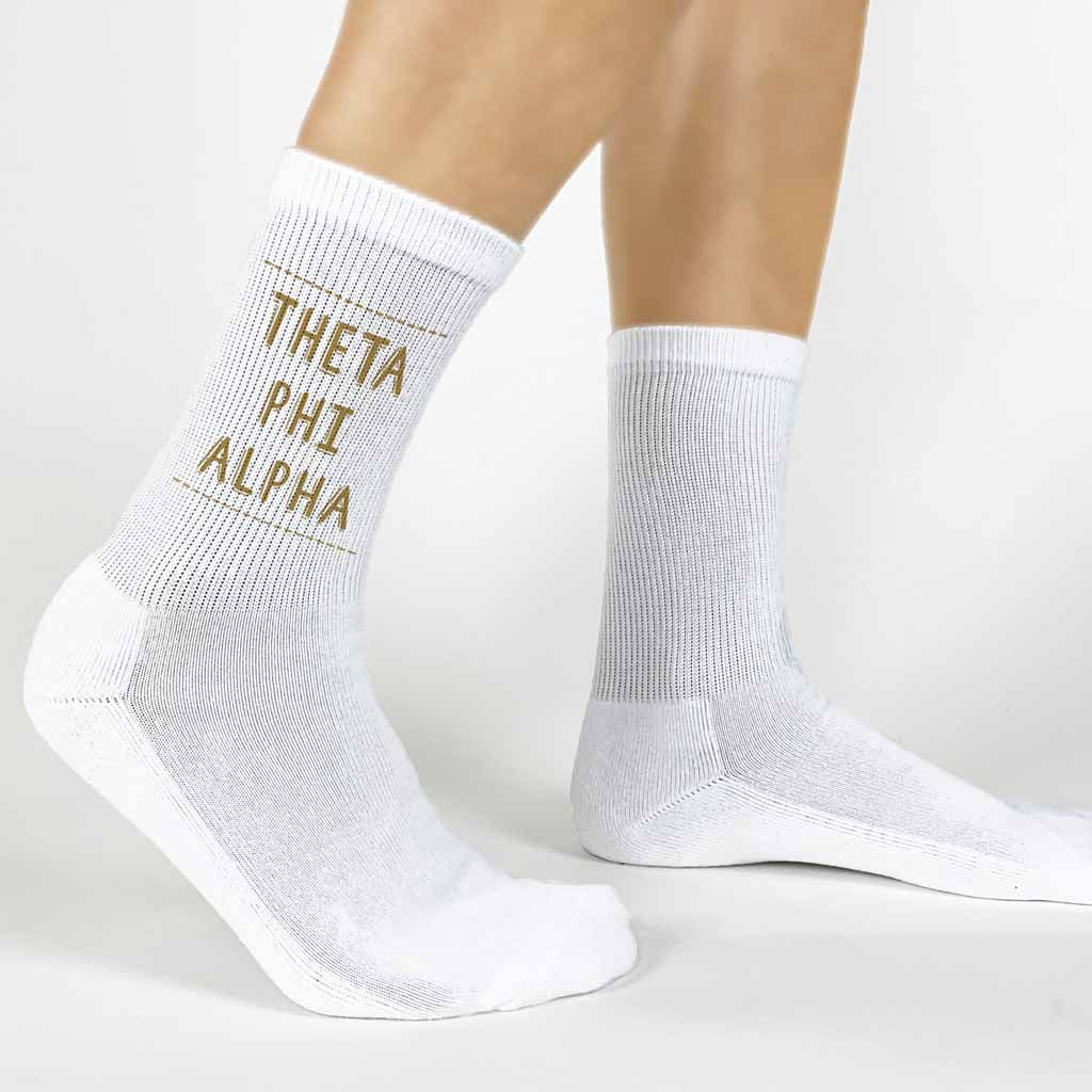 Highlight your Theta Phi Alpha pride with a pair of these Theta Phi Alpha white cotton crew socks printed in sorority colors. 