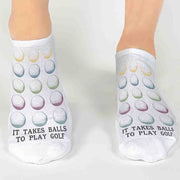 Unique golf ball design custom printed with fun saying it takes balls to play golf on comfy white cotton no show socks is the perfect accessory for the green.
