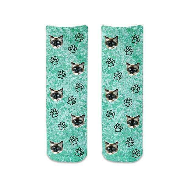 Custom photo face socks digitally printed and personalized using your photo cropped in all over design with paw prints printed on turquoise wash background on cotton crew socks.